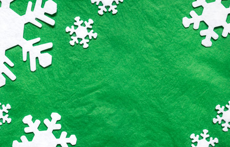 white snowflakes on a green background with copy space.の写真素材