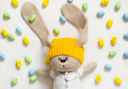 Soft easter bunny toy and lots of colorful eggs aroundの写真素材