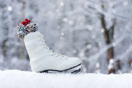 Christmas card with snow, snowflakes and skates on a blurred natural background. Happy New Year, festive mood. Winter background. Copy space.の写真素材