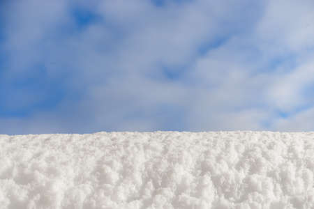 White snow on a background of blue winter sky. Copy space, blank for a design idea. The concept of a festive Christmas mood.の写真素材