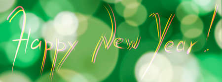 Festive winter background with the inscription Happy New Year. Soft bokeh on a green background.の写真素材