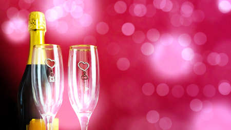 Romantic festive background with two glasses and champagne on a pink background with bokeh. The concept of love and celebration.の写真素材