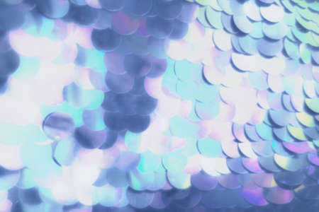 Defocused blue abstract background with sparkles and sequins.