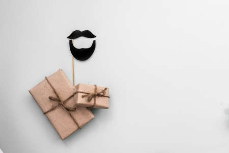 Gift box with kraft paper with a mustache on a light blue background. Flat lay for father's day concept.の写真素材