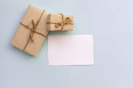 Gift box with kraft paper and a sheet of paper for text on a light blue background. Flat lay for father's day concept.の写真素材