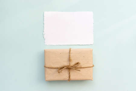 Gift box with kraft paper and a sheet of paper for text on a light blue background. Flat lay for father's day concept.の写真素材