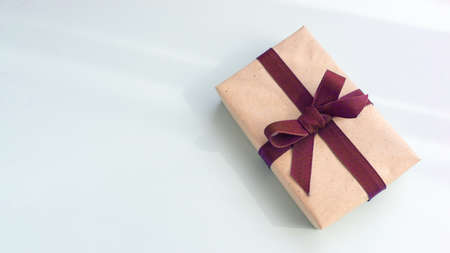 Gift box with kraft paper and a brown ribbon on a light blue background. Flat lay for father's day concept.の写真素材