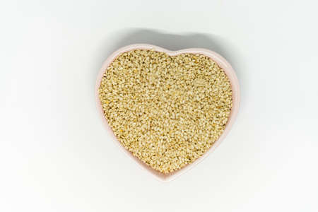 A bunch of sesame seeds in a heart-shaped plateの写真素材