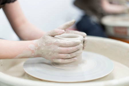 Close-up of a child making handmade ceramics in a ceramics classroom, copy spaceの写真素材