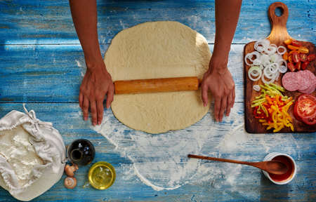 Cook rolls pizza dough, already made a number of ingredients onion, tomato, peppers, sausageの写真素材