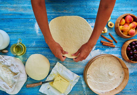 Young girl chef kneads the dough  and rolled with a rolling pin and rolledの写真素材