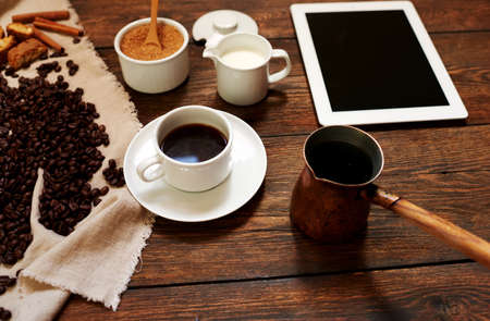 The stylish cafe on the table was served coffee, lying beside the plate, poured in a white cup of...