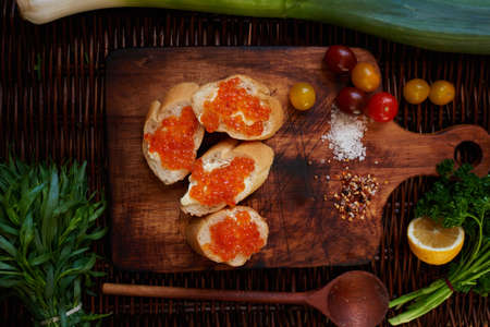 Sandwiches with red caviar, good wholesome breakfast for the entire family, in white crispy baguette buttered salted red caviar on top, served with all the cherry tomatoesの写真素材
