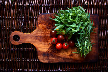 Estragon and tomatoes cherry on the wooden rattan tableの写真素材