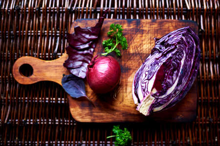 Vegetables lie on a dark wooden textural table, vegetables non-GMO, fresh succulent vegetables on salad, copy space areaの写真素材