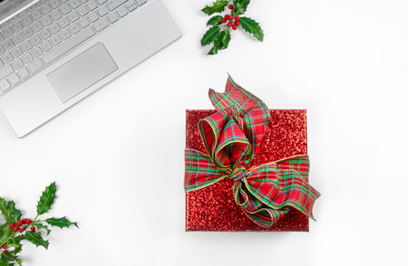 top view of office table with laptop, red present box with a bow for Christmasの写真素材