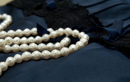White real pearls on blue silk lingerie background.の写真素材