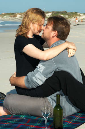 Young married couple looking lovingly into each other's eyes on white sandy beach in South Africa. Shot on a sunny day in winter.の写真素材