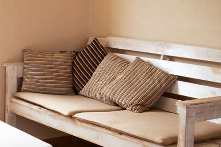 White wooden couch with cushions on it inside the house