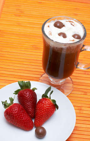 Closeup of coffee with cream (Caffe Borgia) with some strawberries on the sideの写真素材
