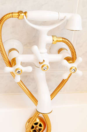 Beautiful gold and white decorative tap in a tiled bathroom の写真素材