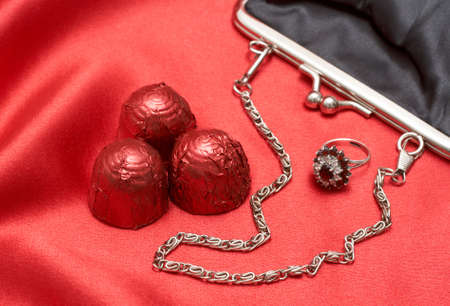 Beautiful black purse with silver chain handles, beautiful engagement ring and chocolate truffles -...