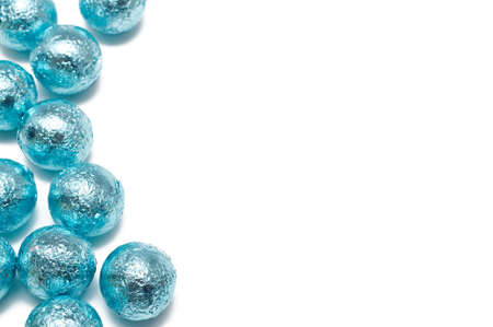 Chocolate Easter balls, wrapped in blue paper on white backgroundの写真素材
