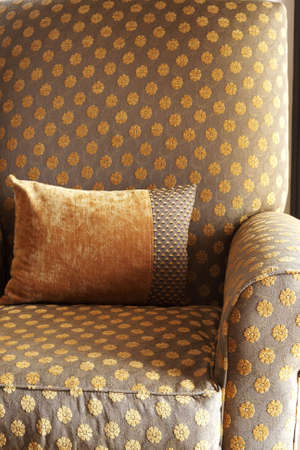 Orange decorative cushion on a chair in a guest lodgeの写真素材