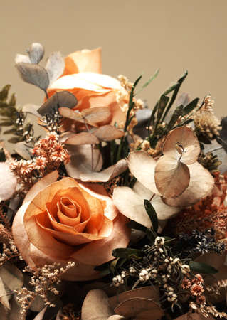 Dry flower bouquet with orange roses and green leavesの写真素材