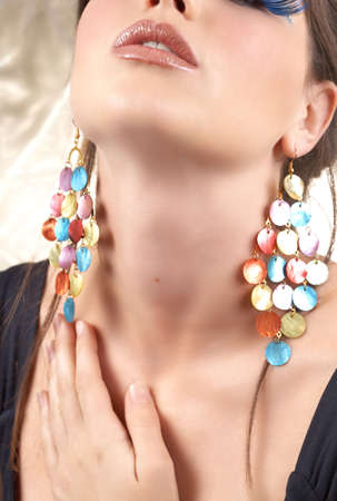 Portrait of a beautiful young brunette woman with dramatic glamour make-up and fashionable earringsの写真素材