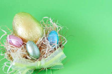 Assortment of chocolate Easter eggs wrapped in colorful paper in straw