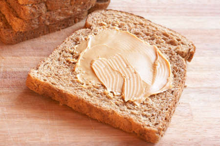 Two slices of Tasty healthy wholewheat bread with peanut butter spread on the table