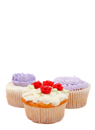 Variety of vanilla cupcakes with various buttercream decorations on white backgroundの写真素材