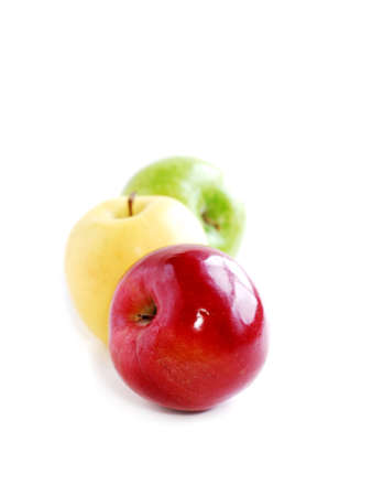 Three apples on white background in perspective: green, yellow and redの写真素材