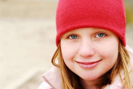 Young girl in a red hat smiling, space for copyの写真素材