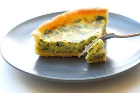 Spinach quiche on a plate with forkの写真素材