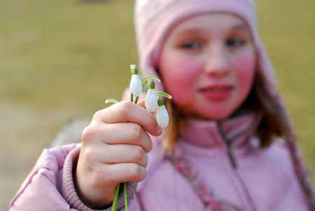Young girl holding first spring flowers in her hand;  shallow dof, focus on the handの写真素材