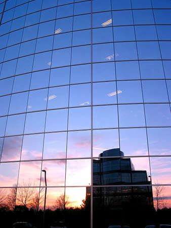 Reflection of a sunset in the mirror glass wall of a corporate buildingの写真素材