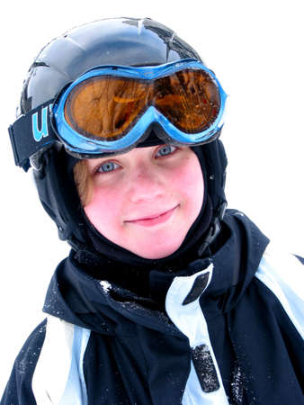 Cute young girl wearing ski helmet and goggles smiles after a day of skiing