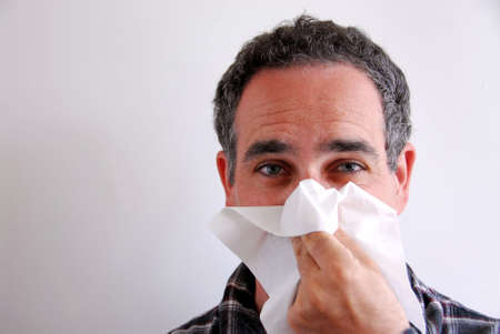 Man with a flu blowing his noseの写真素材
