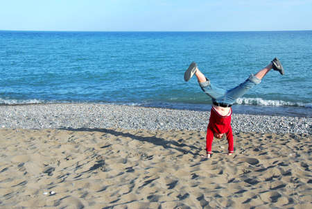 Young girl doing cartwheel on a beachの写真素材
