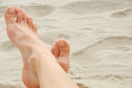 Woman's feet on a sandy beach