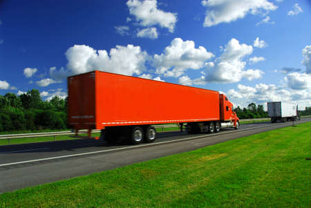 Bright red truck on road, blurred because of fast motionの写真素材