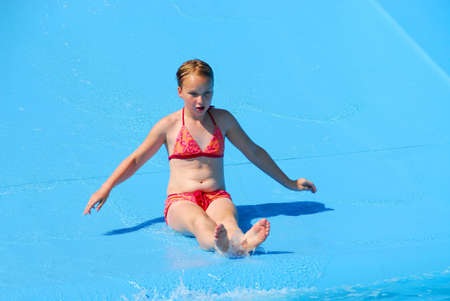 Young girl goind down water slideの写真素材
