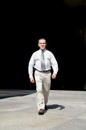 Businessman walking from darkness to light