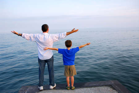 Father and son on a pier relaxing togetherの写真素材