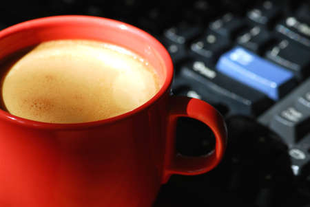 Morning coffee near computer keyboardの写真素材
