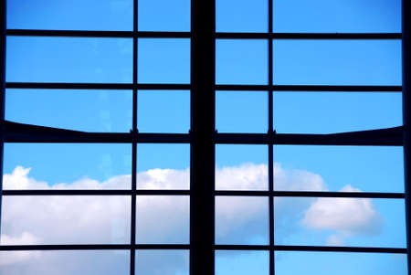 Industrial window with bright blue daytime skyの写真素材