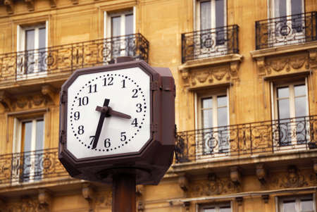 Public clock in Paris on background of old apartment buildingの写真素材
