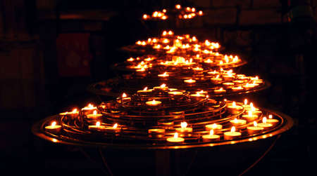 Rows of burning candles inside a cathedralのeditorial素材
